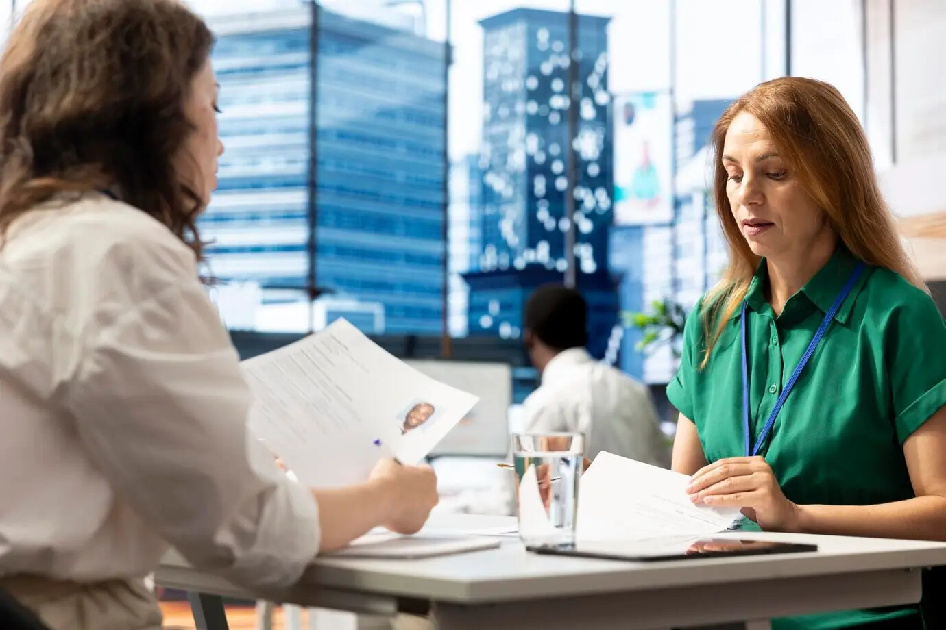 Empleado del departamento de recursos humanos negociando ofertas de empleo y paquetes salariales con un candidato.